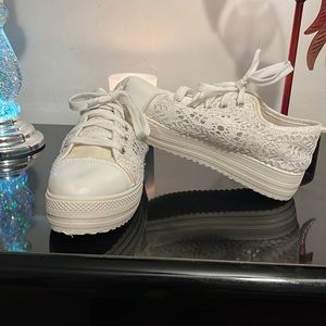 White platform sneakers with open lace on the sides